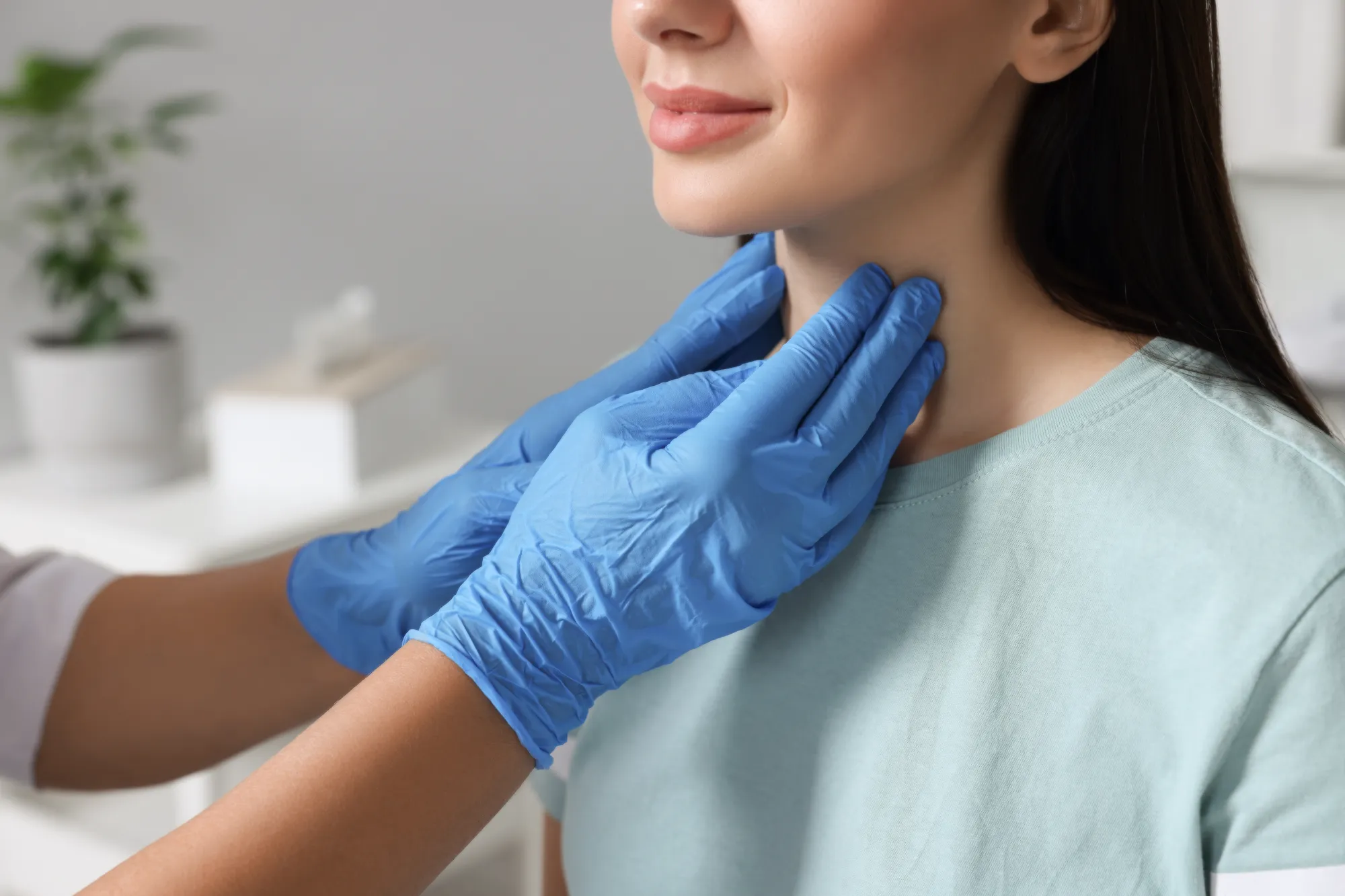 Oncology surgeon checking patient's throat for thyroid nodules