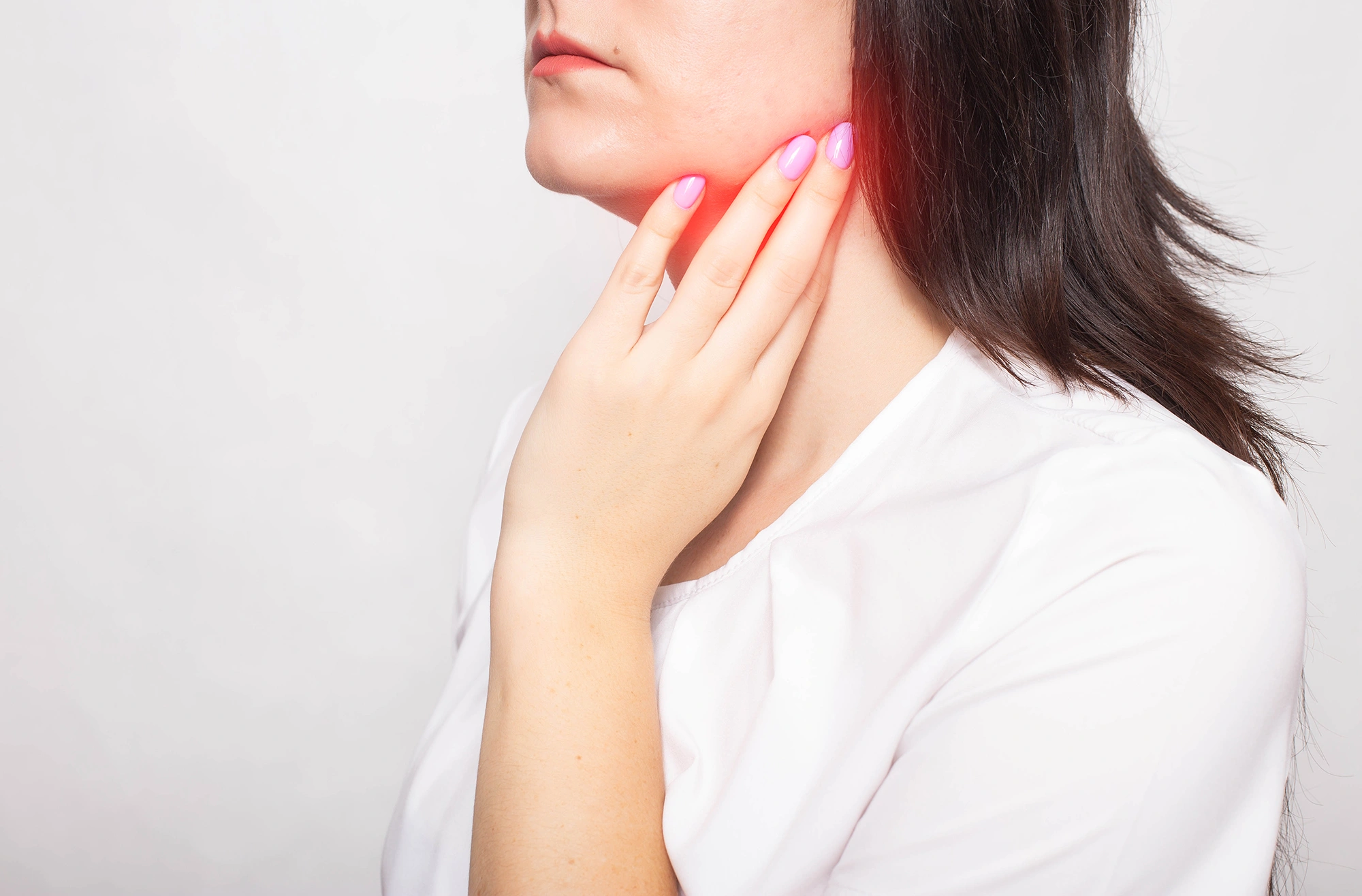 Redness on a woman’s jaw indicating a lump.